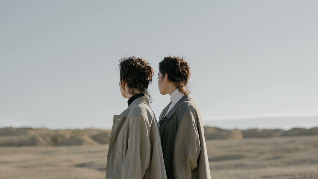 Two people wearing the same clothes and standing in the same way
