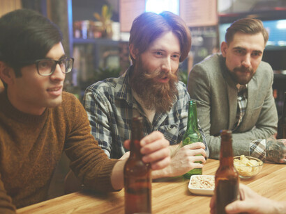 Friends laughing together while talking at a bar
