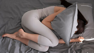 A woman tightly clutching a pillow, seeking a sense of comfort, solace, or emotional support