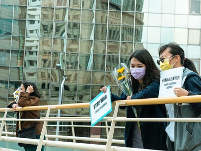 Two Hong Kong locales holding signs for peace for Ukraine 