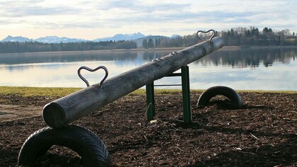 A seesaw waiting to be ridden and staring out into the vastness of the sea