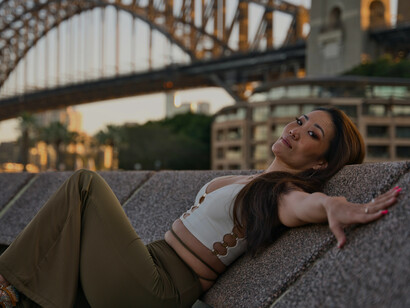 Woman posing near the Sydney Harbour Bridge at sunset, New South Wales, Australia