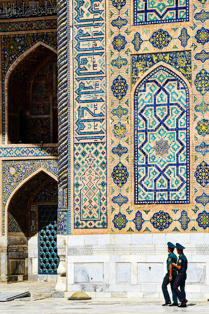 Two policemen walking past a palace in Samarkand, Uzbekistan
