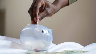 Person putting coins in piggy bank