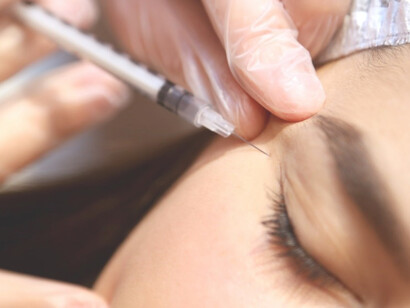 A woman undergoing botox treatment with a doctor