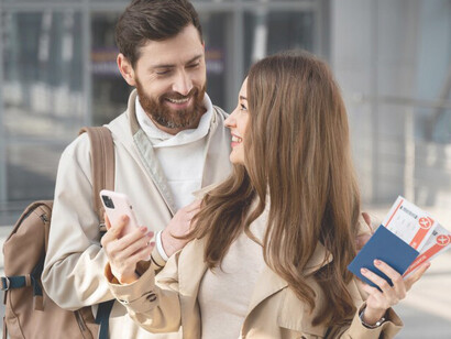At the airport, a happy couple with passports and documents embodies the concept of skilled migration and brain drain as they prepare to move abroad for fresh opportunities