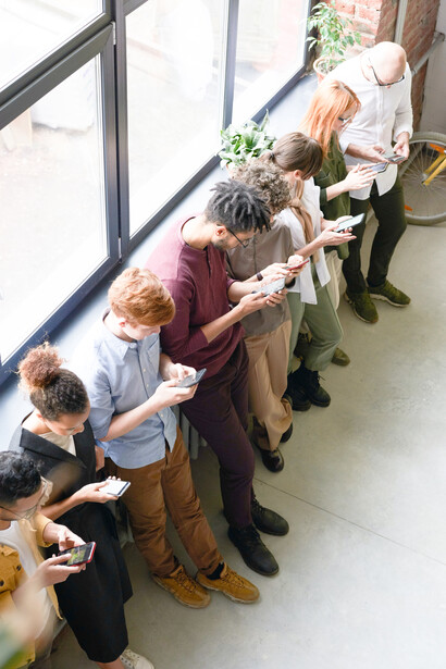 A group of people, all glued with their eyes on their smartphones, not even interacting with one another