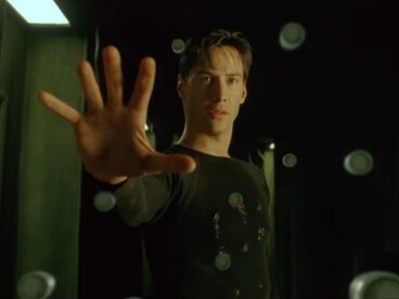 Neo effortlessly halting a barrage of bullets with an outstretched hand, symbolizing the moment he fully realizes his mastery over the simulated world of The Matrix