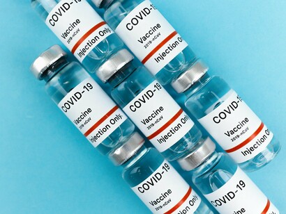 Several COVID-19 vaccine bottles gathered on a flat surface, reflecting the scientific response to a global emergency