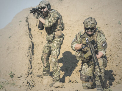 In the desert, two soldiers stand