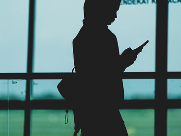 Surabaya, East Java, Indonesia, a woman’s silhouette with a backpack at an airport terminal