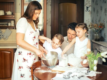 Mãe cozinhando com seus filhos