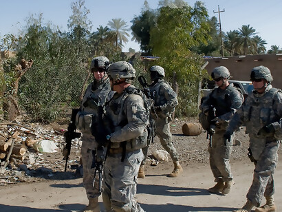 Civilians and soldiers sharing a war-torn street in Diyala, Iraq