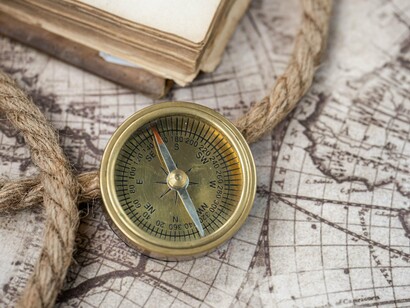 A vintage compass on top of an aged map, symbolizing the continuity of Russia's imperial aspirations across generations