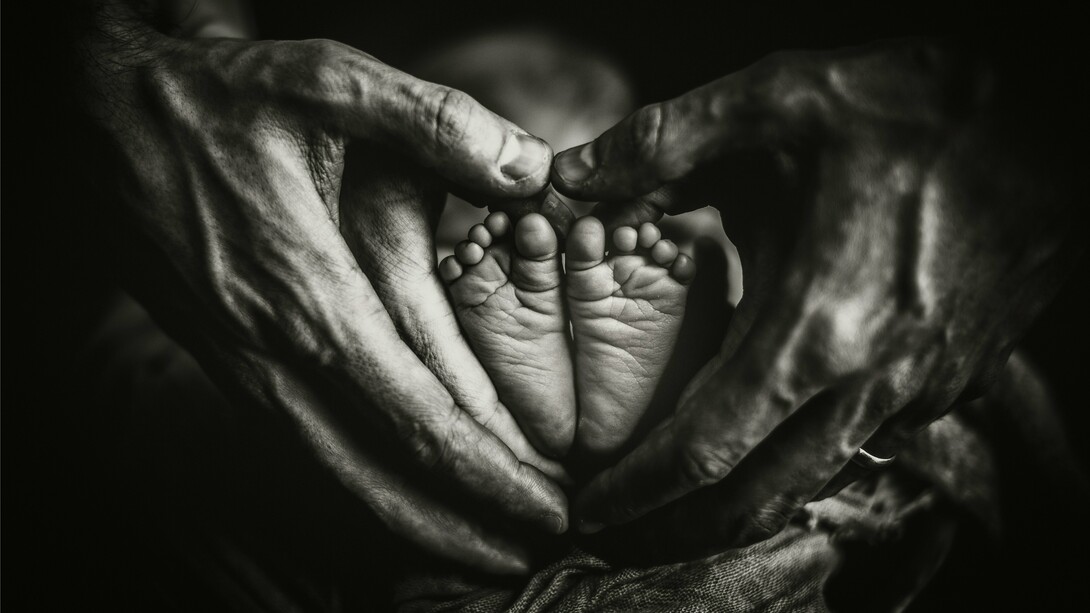 As mãos de dois adultos envolvem os pés de um bebê em formato de coração, simbolizando proteção, cuidado e a continuidade dos laços familiares. O artigo defende que a família deve permanecer como a principal fonte de orientação para as novas gerações. A transmissão de ensinamentos entre gerações é apontada como um dos pilares para a construção de lares duradouros. A transmissão de ensinamentos entre gerações é apontada como um dos pilares para a construção de lares duradouros