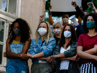 A diverse crowd of demonstrators taking part in a women's march and public protest