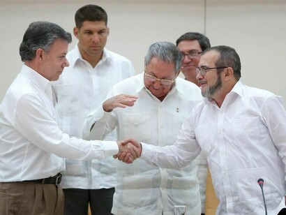 Apretón de manos entre el presidente colombiano Juan Manuel Santos y Rodrigo Londoño Echeverri, Timochenko, líder de las FARC, en presencia del presidente cubano Raúl Castro