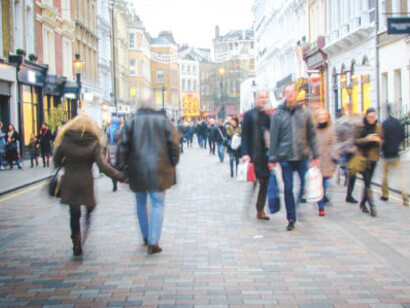 People walking along a busy High Street shopping area in the UK