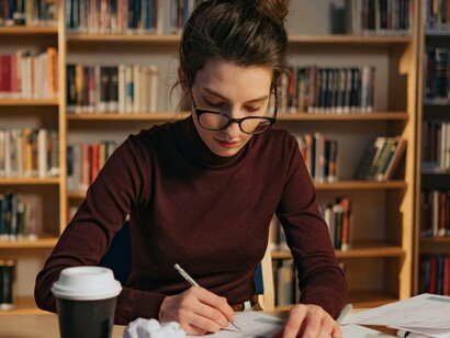 Mulher escreve livro. O livro é um objecto que nos leva para várias dimensões em simultâneo, para caminhos bifurcados, como nos lembra Borges, para memórias ancestrais e sonhos inconfessáveis