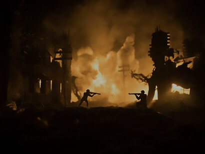 Military silhouettes engage in a fighting scene against a war fog sky background, depicting World War soldiers silhouette below a cloudy skyline at night, amidst a battle in a ruined city