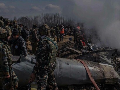 Armed forces gather around a wreckage site in the Kashmir region in an attempt to understand and clear up the debris