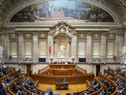 O plenário da Assembleia da República reúne deputados responsáveis pela elaboração das leis e fiscalização do governo. A fotografia reforça a discussão do artigo sobre instabilidade política e representação democrática