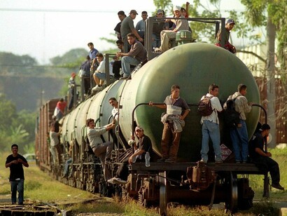 Emigrantes agarrados al vagón cisterna de un tren