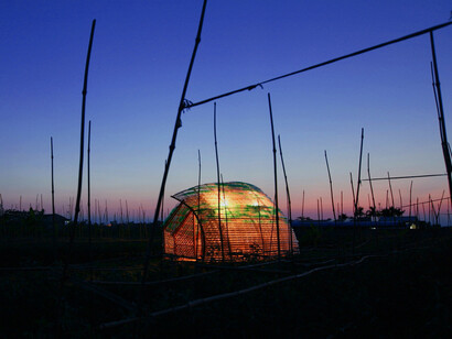 Silhouetted against a twilight sky, the Bottle Sail's curved structure in Haiphong, Vietnam, highlights the beauty of recycled design in harmony with nature