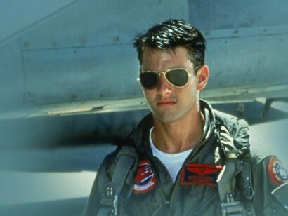 Tom Cruise em cena do filme Top Gun. No longa, somos apresentados a uma figura clara de um herói indomável, Maverick, interpretado por Tom Cruise. Ele tem sua bela namorada e, supostamente, luta por um ideal maior de liberdade e vitória da nação norte-americana. A imagem de um indivíduo que, apesar de desrespeitar as regras e a hierarquia, consegue completar as missões com êxito e salvar os interesses americanos de uma suposta liberdade e bem comum, é profundamente problemática