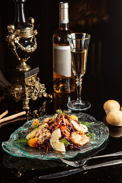Side view of a chopped vegetable salad with chicken and pineapple on a plate, placed on the table