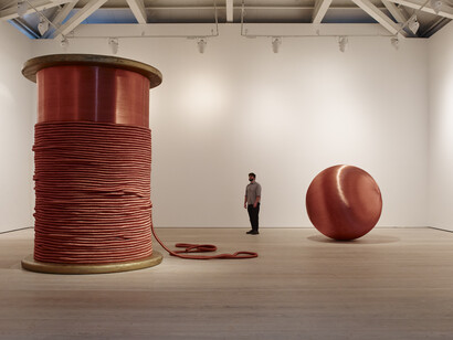 Alice Anderson, Left: Bound 2011 Bobbin made of wood and copper thread 345 x 248 x 248 cm,
Right: 181 Kilometers 2015 Sculpture made after performances, copper thread 200 cm (diameter) Image (c) Steve White, 2015, Courtesy of the Saatchi Gallery, London