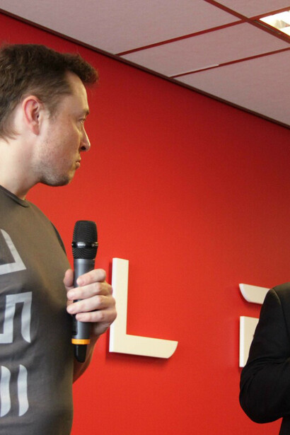 Elon Musk during a press conference; his contributions to AI and his efforts to merge it with the human brain through Neuralink are shaping the future of technology