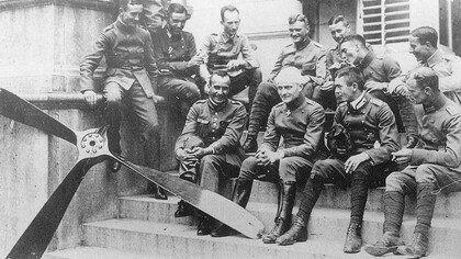 The Red Baron with his bandage seating with his flying circus in the summer of 1917, Carlos in the back row lighting a cigar