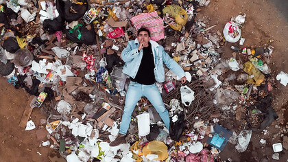 Man lying on garbage pile, Peru, Villa EL Salvador
