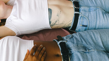 Mulheres deitadas conversam sobre seus ciclos mentruais em uma troca descontraída 