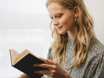 Woman reading a book in a quiet indoor space