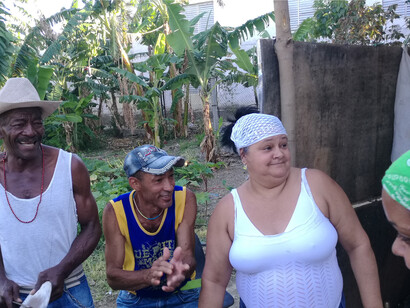 La gente baila y canta durante una ceremonia de santería. A la derecha se encuentra la cabeza de una mujer joven, que se cree que es la hija de Shang, como lo indica un pañuelo verde. Mantilla, La Habana, Cuba