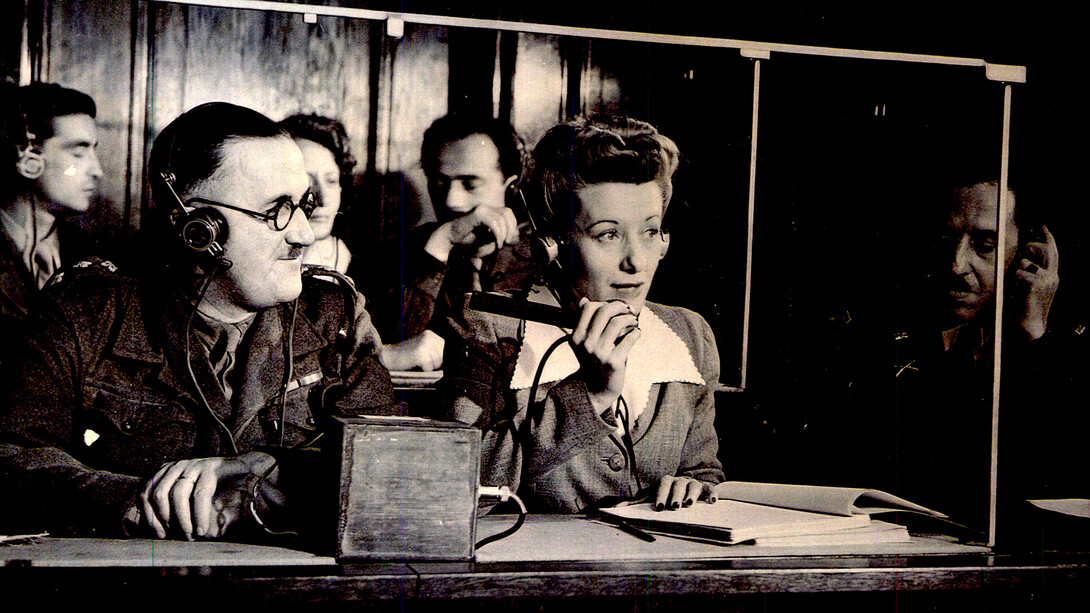 Die Dolmetscher bei den Nürnberger Prozessen: Dolmetscher im Saal bei der Arbeit; v.l.n.r.: Capt. Macintosh, British Army, (Franz.-Englisch), Margot Bortlin (Deutsch-Englisch), Lt. Ernest P. Uiberall (Monitor)