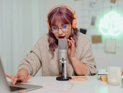 Through her podcast microphone, a woman becomes a voice in the digital town hall—an emblem of today’s online communities and public discourse