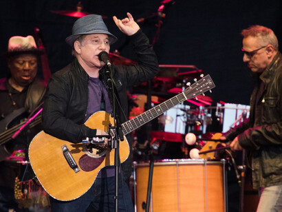 Paul Simon alla chitarra durante un concerto