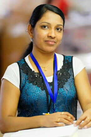 A Sri Lankan worker, immersed in her duties at a textile factory in Jordan, momentarily gazes at the camera, her eyes reflecting a blend of determination and quiet resilience