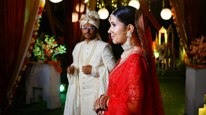 A radiant bride and groom celebrating a traditional Kumaoni wedding, adorned in vibrant attire and cultural splendor