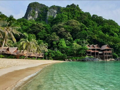 This tranquil image of a luxurious island resort represents the traditional ideal of high-end travel, now being re-evaluated for a shift towards experiences that cultivate inner growth and transformative personal development rather than mere material indulgence