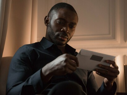 A man staring at the envelope containing a letter, reflecting how handwritten messages become cherished keepsakes