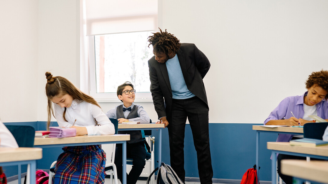 Professor media trabalho de alunos em sala de aula