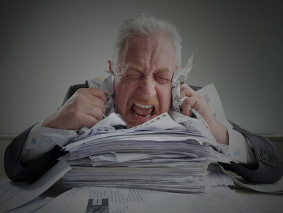 An entrepreneur overwhelmed by government paperwork, crumpling documents at a desk