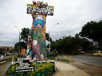 O Monumento a la Resistencia se ergue em meio ao movimento cotidiano de Cali, no local conhecido como Puerto Resistencia. Construído no próprio território das mobilizações, o memorial mantém a lembrança do estallido social integrada à paisagem e à vida da cidade. A obra deixou de ser apenas uma escultura para se tornar também lugar de memória, debate e disputa sobre o significado daquele período ocupando o espaço onde a mobilização popular ganhou uma de suas expressões mais fortes