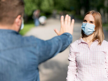 COVID-19 social distancing practices in a park: a man and a woman keeping safe distance outdoors