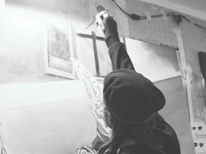 Tyrone Egbowon drawing a cross for his latest artwork