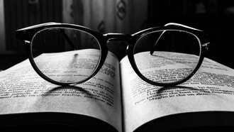 Gafas encima de un libro abierto de literatura